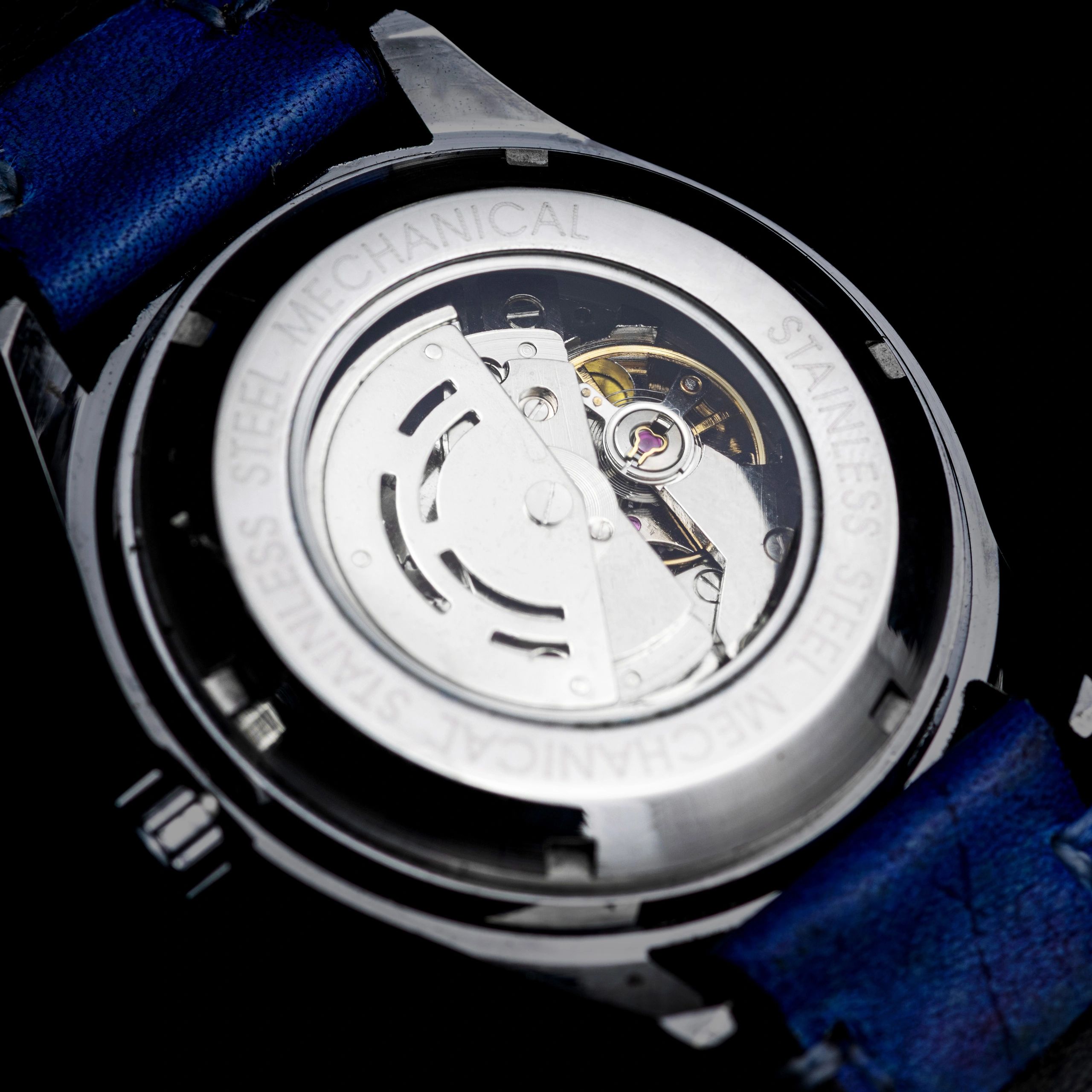 Close-up mechanical watch movement on black background
